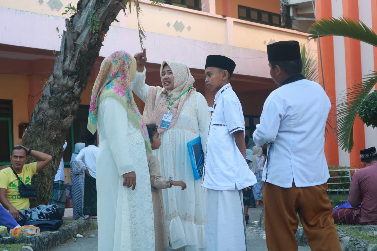 Wali santri besama anaknya menayakan sesuatu kepada seorang ibu-ibu yang sedang melintas, Minggu (18/6/2023). [Sukma Agung Adi Luwih/alfikr.id]